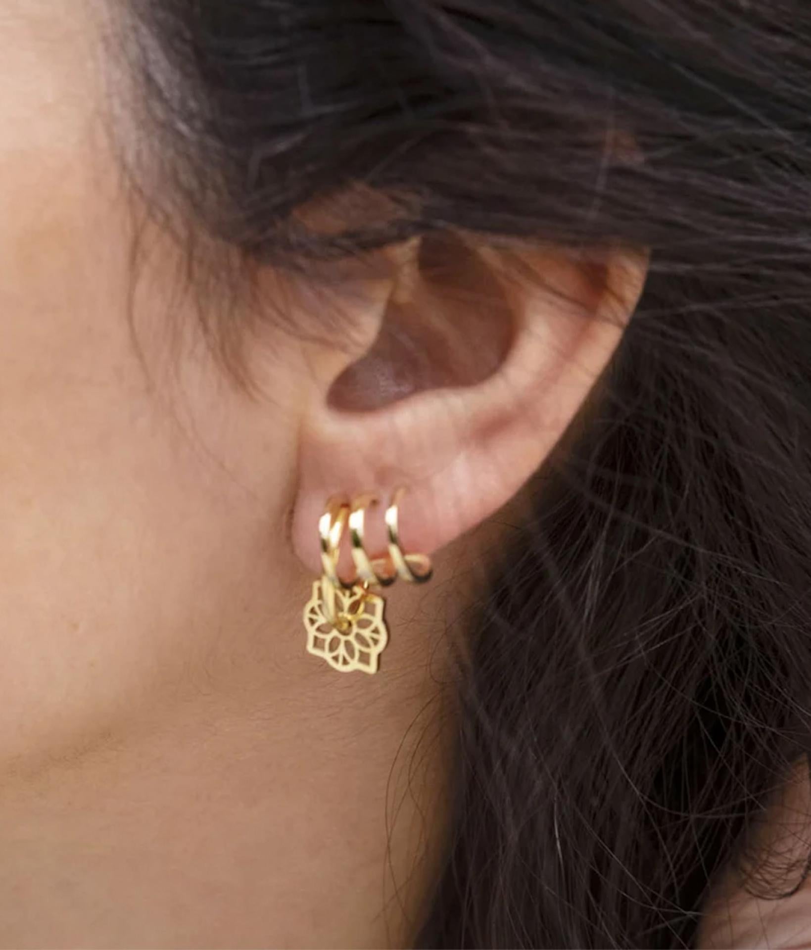 braunhaariges model am linken ohr mit Zag Bijoux Ohrringe aus goldenen halbringen
