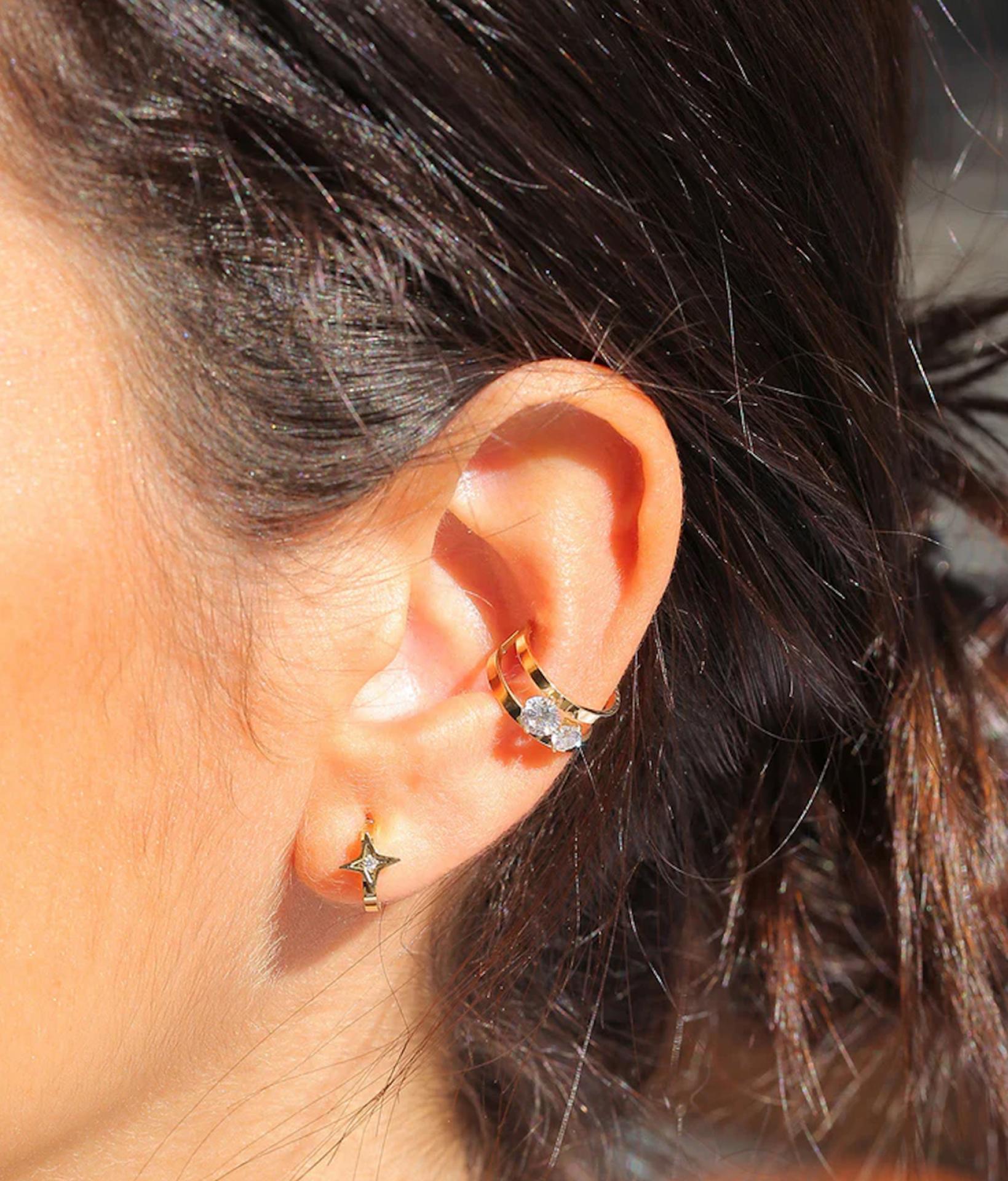 Frau trägt modische Ohrringe von Zag Bijoux, bestehend aus einem Ohrstecker in Stern Form und einem goldenen Earcuff mit Zirkonia Stein